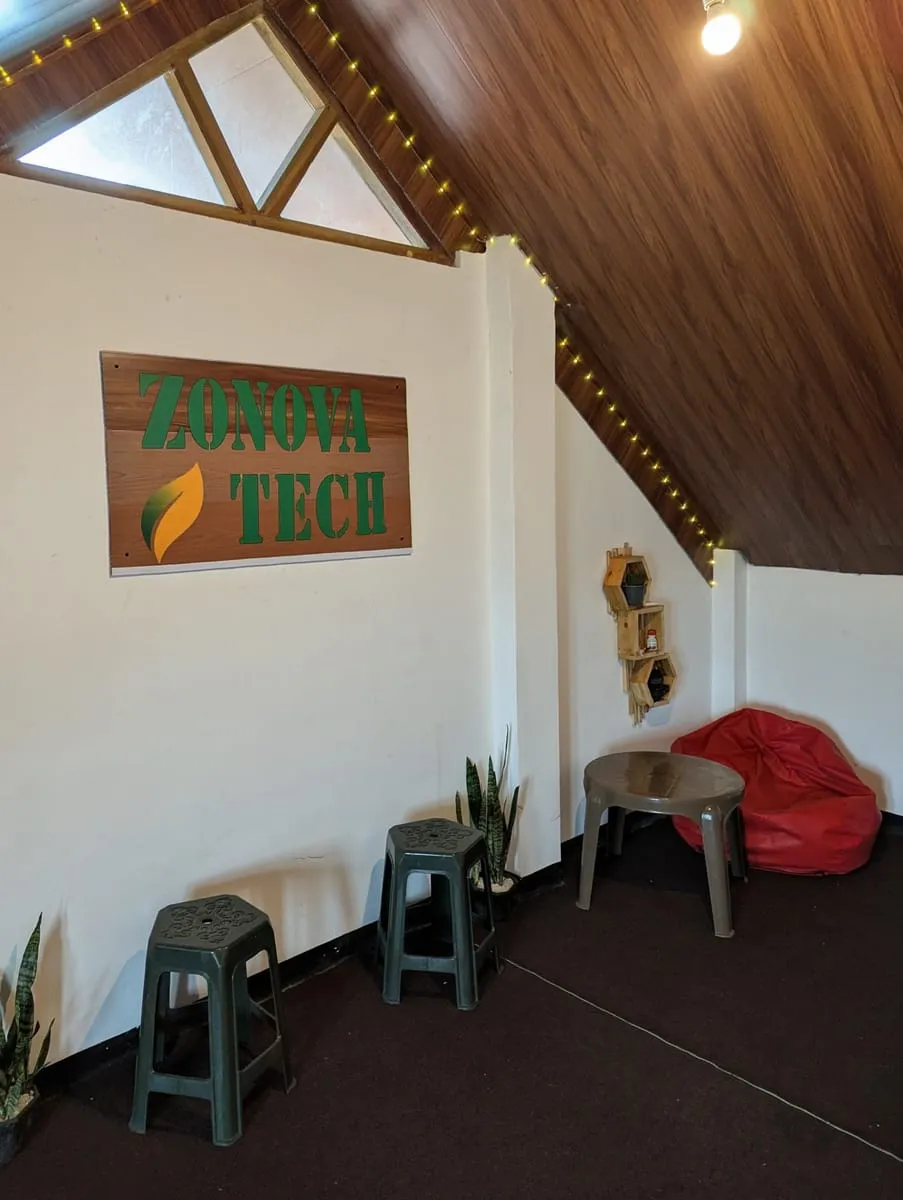 The studio's attic room: the wooden sign on a white wall, stools, a red beanbag and a triangular skylight.