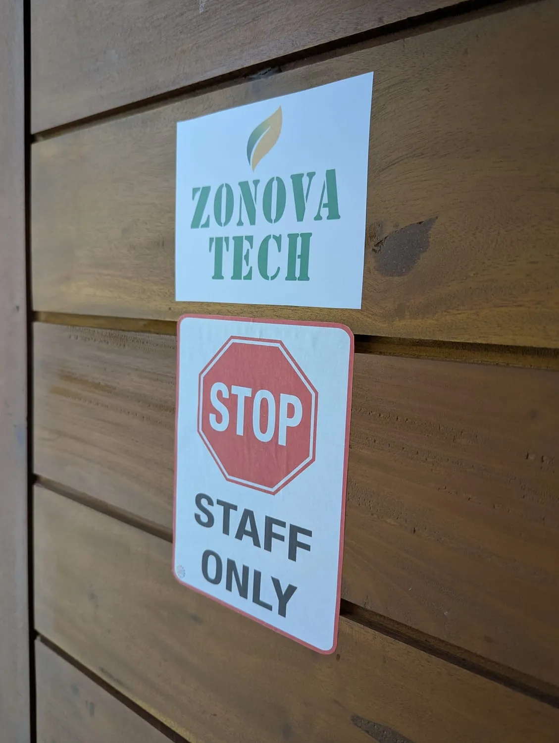 The studio door, with a Zonova Tech sticker and a 'Stop — staff only' sign on the timber cladding.